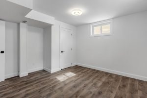 an-empty-room-with-white-walls-and-wooden-floors-oaclq1shi1k